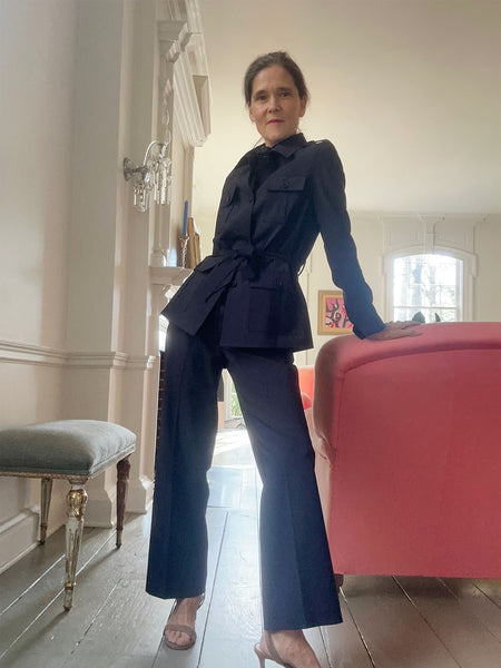 Ann at home in her tropical wool safari pantsuit. She's wearing her hair in a low bun and has camel suede kitten heel sandals on.
